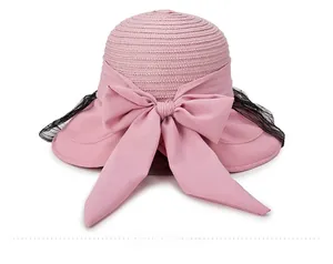 Detail view of pink straw sun hat with large silk bow and delicate black lace mesh