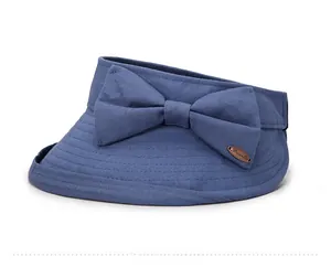 Detail view of large bow ornament and metal logo plate on blue foldable sun visor hat