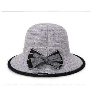 Front detail of grey hollow knit sun hat featuring a delicate two-tone bow and brand tag