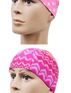 Detailed view of elastic swim caps featuring pink polka dot and wavy patterns on a model
