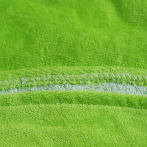 Detail of green cotton toddler hooded bathrobe showing fabric texture and sewing quality