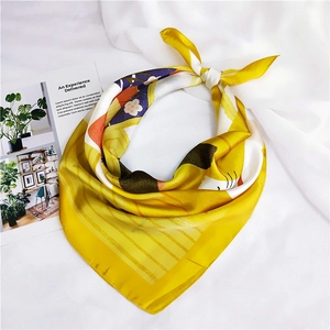 Detail of silk scarf with yellow and purple cat print on elegant white fabric