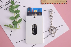 Detail of white card holder with metal keychain and oval window showing card storage