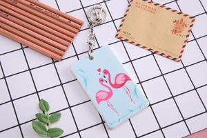 Detail of light blue ID card holder with pink flamingo pattern and metal keychain