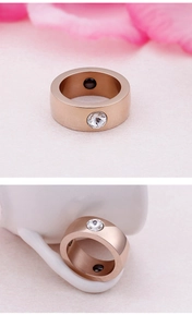 Detail view of rose gold stainless steel ring with a sparkling inset zircon and inner inlay