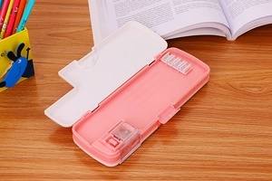 Detail view of the open pink stationery box showing built-in sharpener and pencil slots
