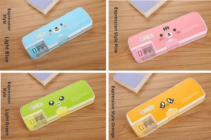 Detail of four colorful cartoon pencil cases with built-in sharpeners on a wooden desk