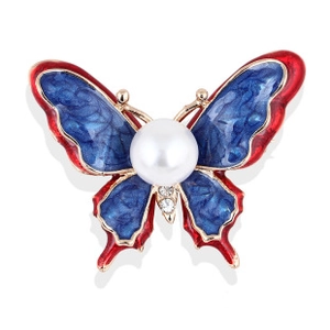 Detailed close-up of butterfly brooch with red and blue enamel, pearl, and rhinestones