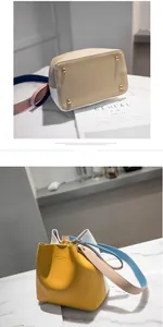 Macro shot of color-block bucket bag base with gold metal studs and blue leather strap