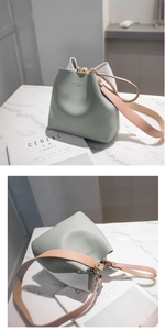 Detail view of contrast color bucket bag with wide strap and premium matte leather texture