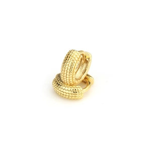 Macro-opname van 18k vergulde huggie-oorbellen met een unieke gedetailleerde korrelige textuur