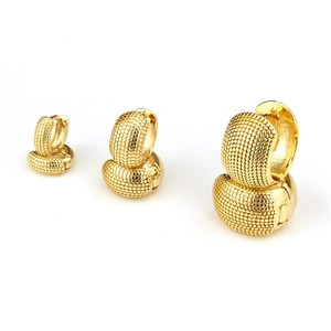 Detailweergave van drie maten gouden chunky creolen met fijne kralentextuur op het metaal