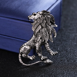 Macro shot of an antique silver lion brooch with leaf textures on a jewelry box