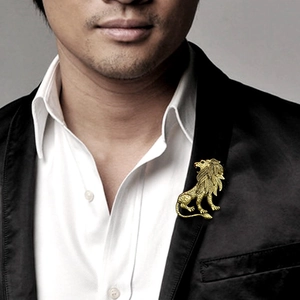 Vintage golden lion brooch accessory on a black suit jacket for a trendy professional look
