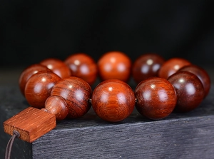 Macro shot of polished Brazilian Rosewood beads showing natural wood grain and oil finish