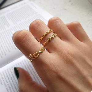 Three-piece 925 sterling silver gold LOVE ring set styled for layered wearing on fingers