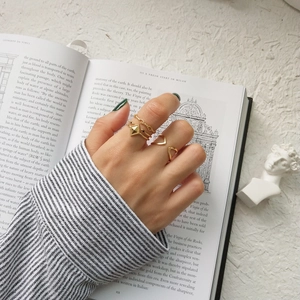Minimalist gold stackable geometric ring set featuring textured band and V-shape design