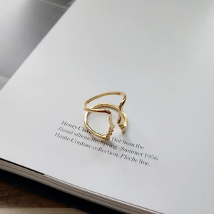 Artistic gold S925 sterling silver face silhouette ring on a minimalist book background
