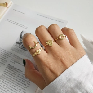 Four-piece gold plated ring set with crescent, ruby, and LOVE engraving on a model hand