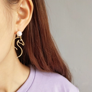 925 silver golden horse head earrings with white pearl detail on female model