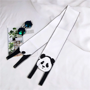 Detail of a panda theme skinny scarf with black and white print on a soft white background