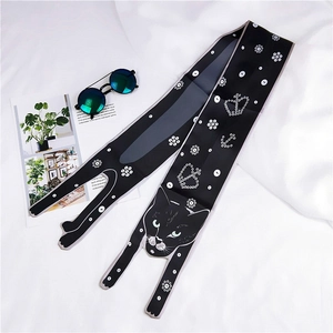 Detailed view of a long silk scarf featuring a black cat print and white crown patterns