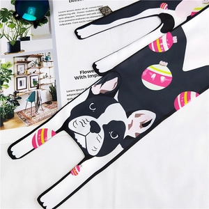 Detail of cartoon French Bulldog print silk scarf with festive ornaments on a book