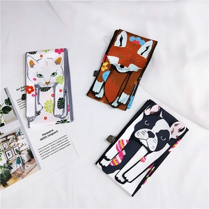 Detailed view of polyester scarves with cartoon cat, fox and frenchie animal prints