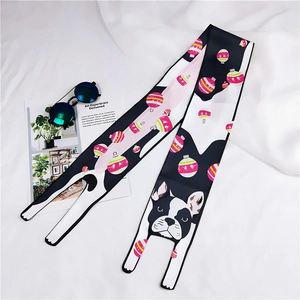 Detail view of cartoon dog print silk scarf styled with sunglasses on white fabric