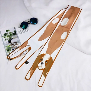 Close-up of a long silk scarf featuring cartoon dog prints with sunglasses on white fabric