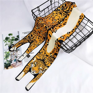 Close-up of leopard print silk scarf with black and brown spots draped in a basket