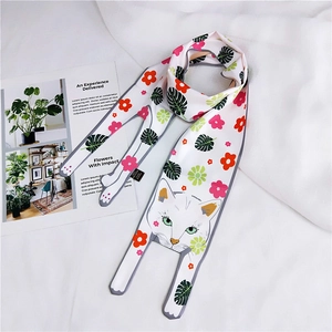 Detail of white silk scarf with floral cat print and 100% polyester fabric label