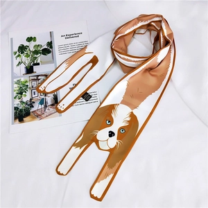 Detailed shot of a cartoon spaniel dog pattern long silk scarf on a white fabric surface