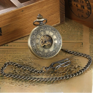 Detail of vintage hollow mechanical pocket watch with bronze floral relief and Roman numerals