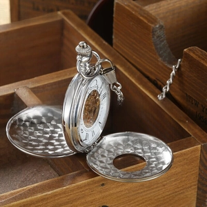 Macro detail of silver mechanical pocket watch with hollow dial and Roman numerals