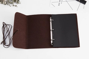 Flat lay of retro felt DIY scrapbooks with leather straps and black inner pages