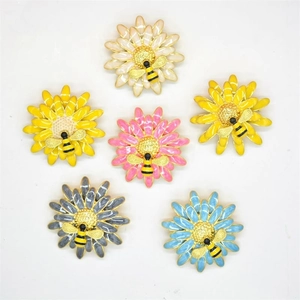 Detailed view of six colorful enamel flower brooches with small bees on white background