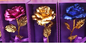 Detailed view of three gold foil roses in blue, purple, and gold colors with gift boxes