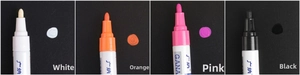 Detail of white, orange, pink and black paint marker tips showing fiber nibs and ink coverage