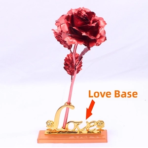 Detail view of a metallic red artificial rose with a golden 'Love' engraved base stand