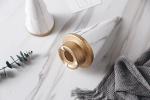 Detailed macro view of ceramic cone ring holder with marble texture and golden metal base