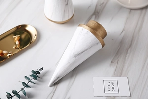 Close-up of marble pattern ceramic cone ring holder with elegant gold leaf base detail