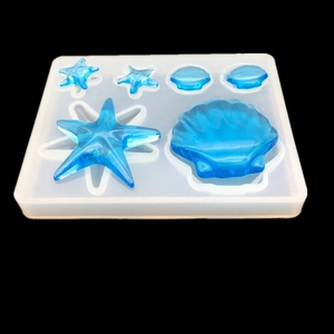 Macro detail van siliconen mallen met schelp en zeester en blauwe hars ambachten