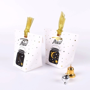 Elegant white gift box with gold ribbon and Merci branding for holiday candy packaging