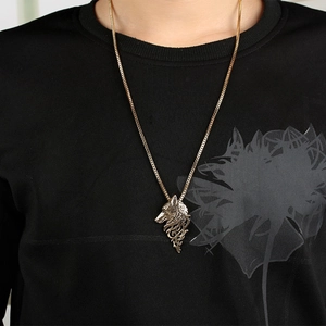 Detailed close-up of a golden wolf head pendant on a vintage box chain necklace