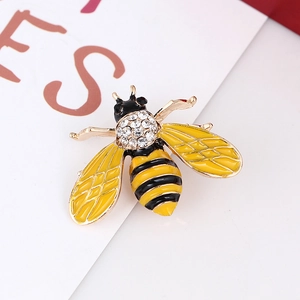 Macro shot of bee brooch detailing yellow enamel wings and sparkling inlaid rhinestones