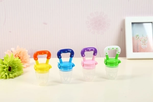 Set of four colorful baby fruit feeders in yellow, blue, pink and green for infant feeding