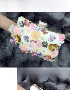 Detailed close-up of handmade 3D floral embroidery and sparkling crystals on evening bag