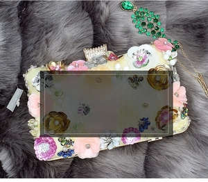 Exquisite handmade evening bag detail with 3D fabric flowers, sequins and pearl accents