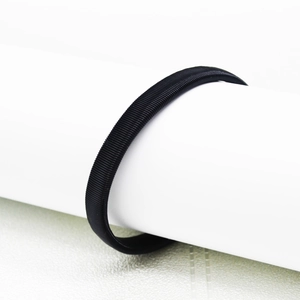 Detail of a black elastic metal spring sleeve garter for men on a white background